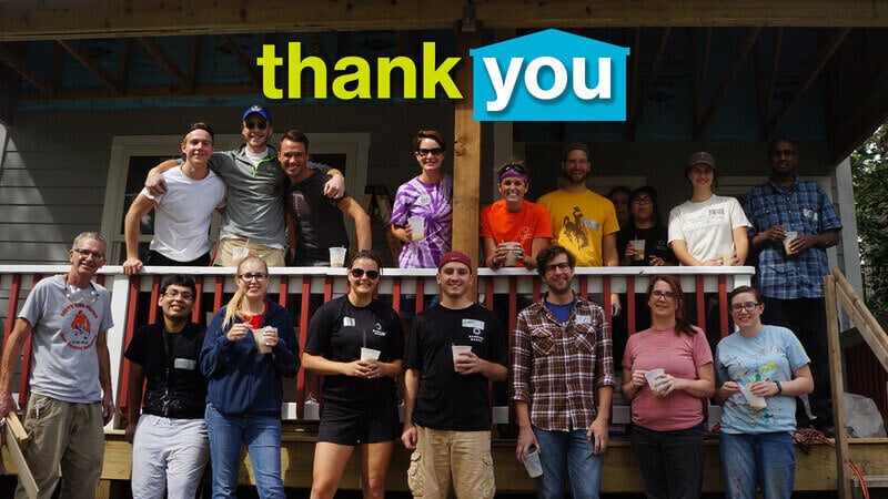 A group of volunteers standing on a porch. 