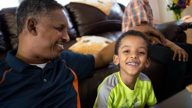 Ahmed and his son in their living room.