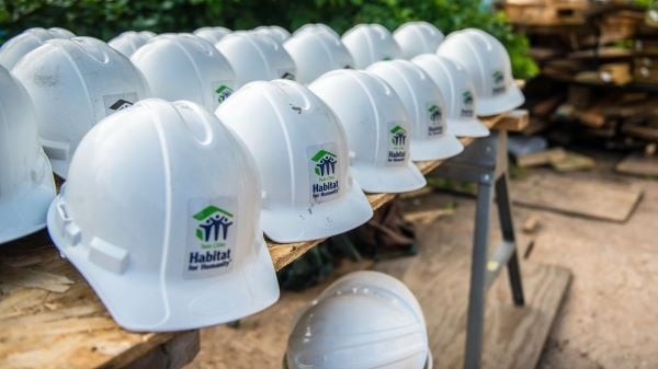 white hard hats on a construction site with twin cities habitat for humanity logos