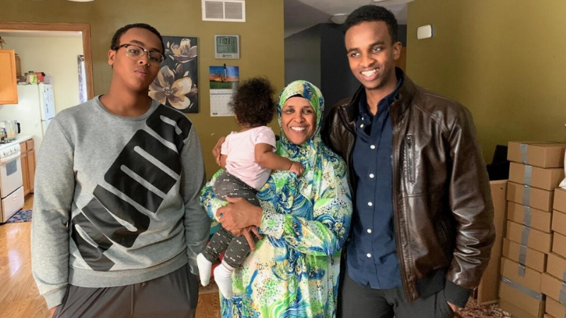 Hamida standing with her children in her Habitat home