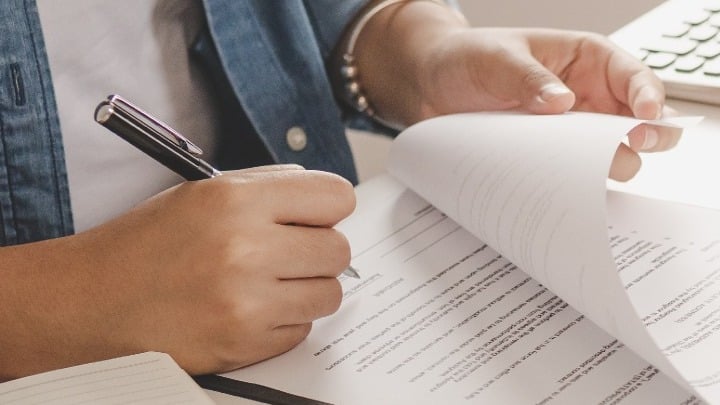 Close-up of a person signing a purchase agreement 