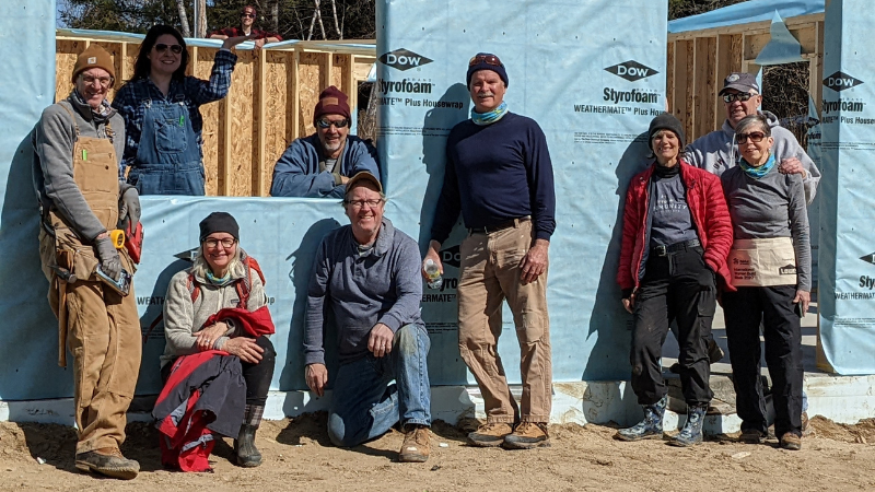 Twin Cities Habitat volunteers standing by a wall they raised
