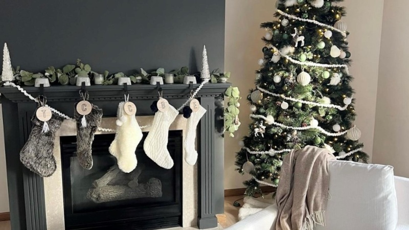 Minimalist handmade yarn stockings and ornaments in a living room.