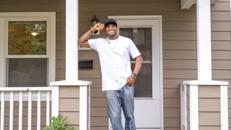 James Hargon standing on the front porch of his Habitat home