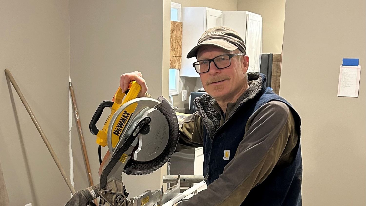 Michael using a saw on the build site.