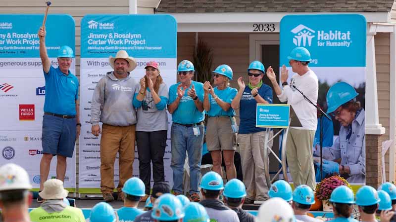 Chris Coleman holding up the hammer at the Carter Work Project