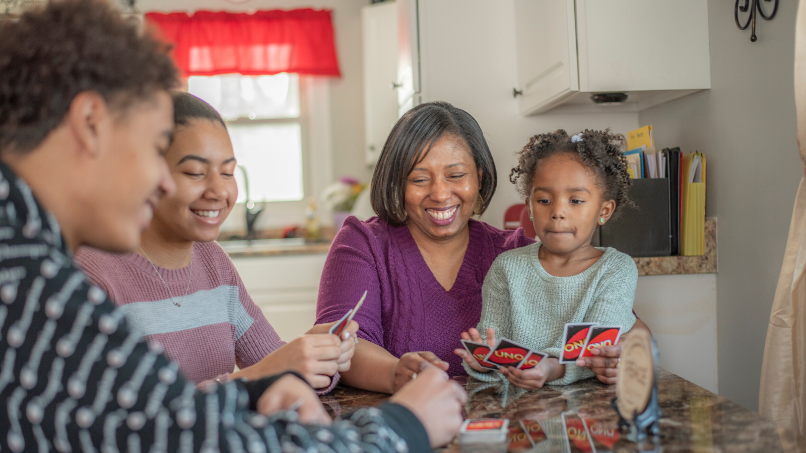 LaShonda and her family sitting at the kitchen table playing Uno.