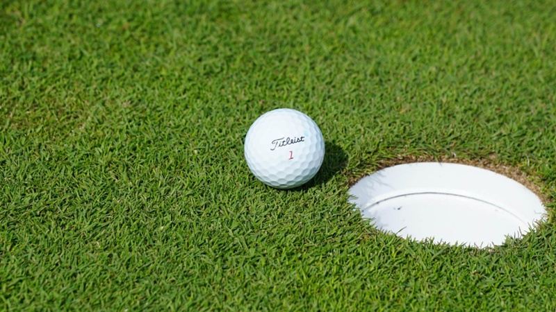 A close-up of a golf ball on a course.