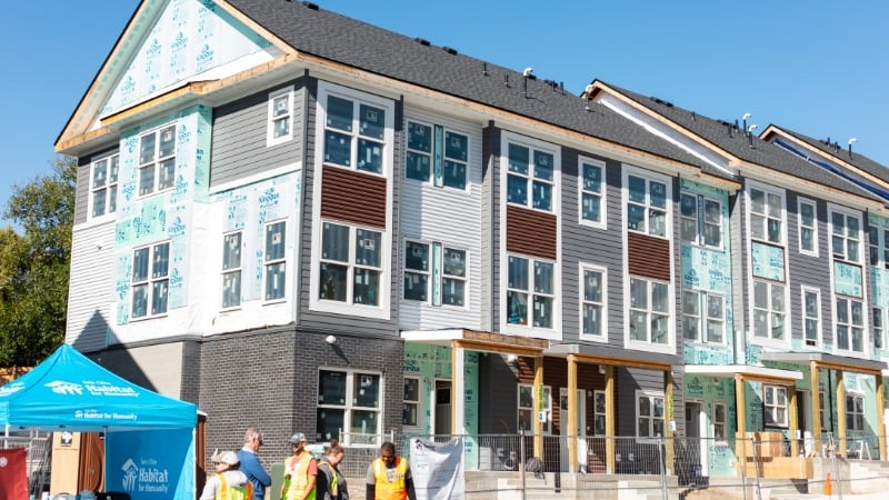 Exterior shot of townhomes with unfinished siding.