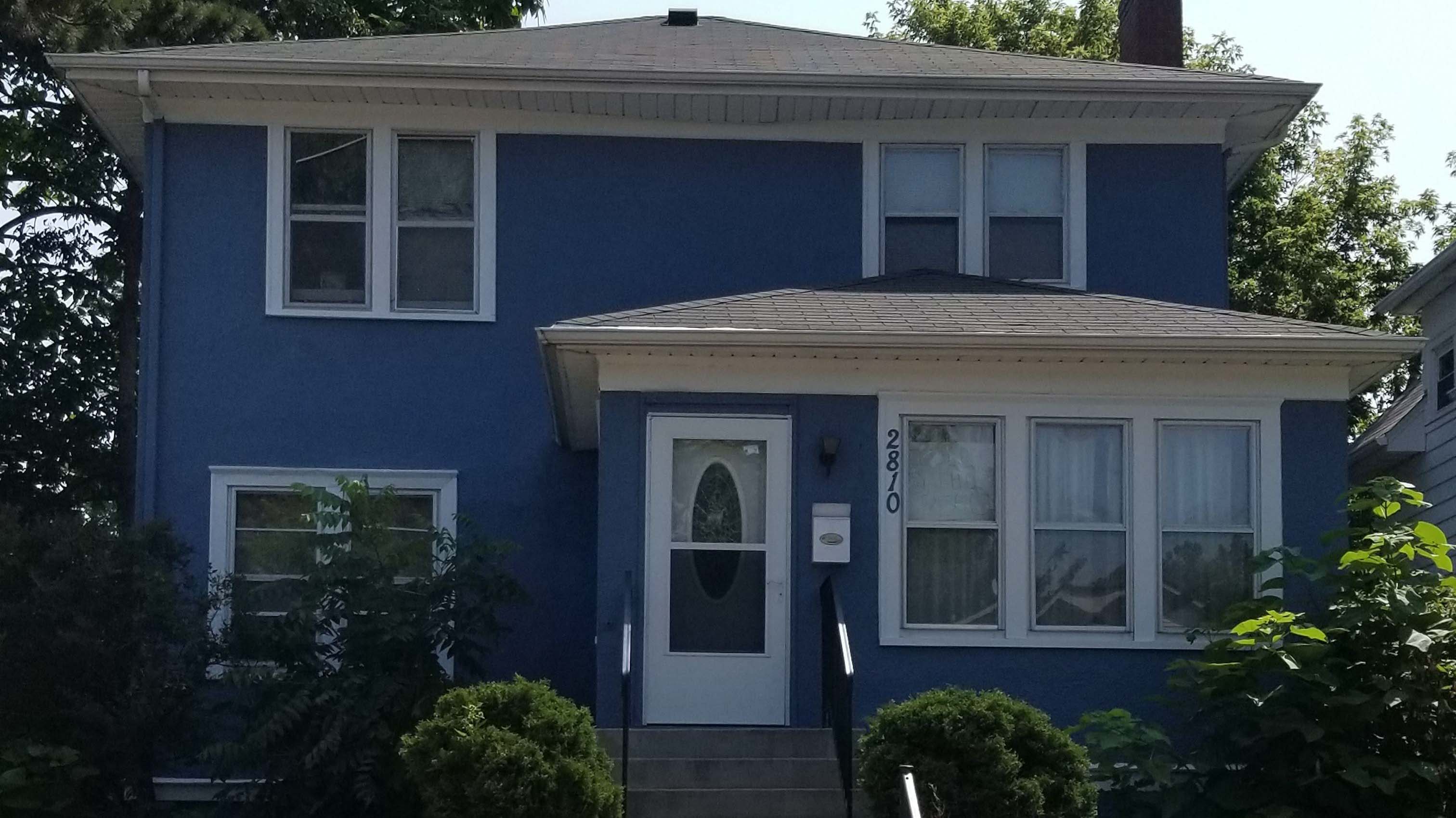 A blue house with a new railing in the front.