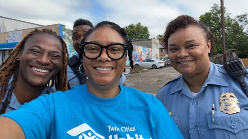 Shereese taking a fun selfie with three local police officers.