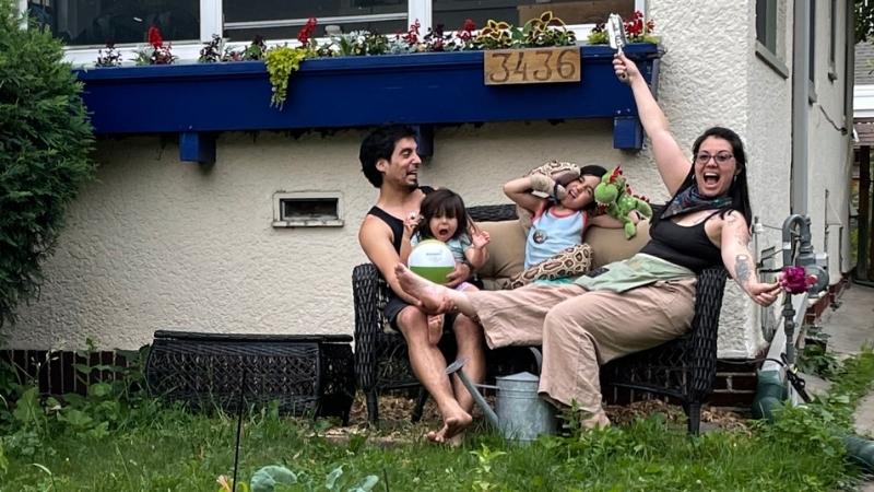 Matias, Camila, and their two kids on a bench being silly.