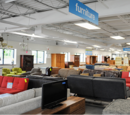 A shot of the interior of the ReStore, with bright white lighting above the furniture section.