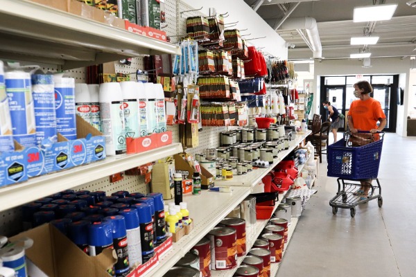 Shopper with cart browsing shelves of home improvement products