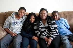 Kenisha sitting on the couch with her family 