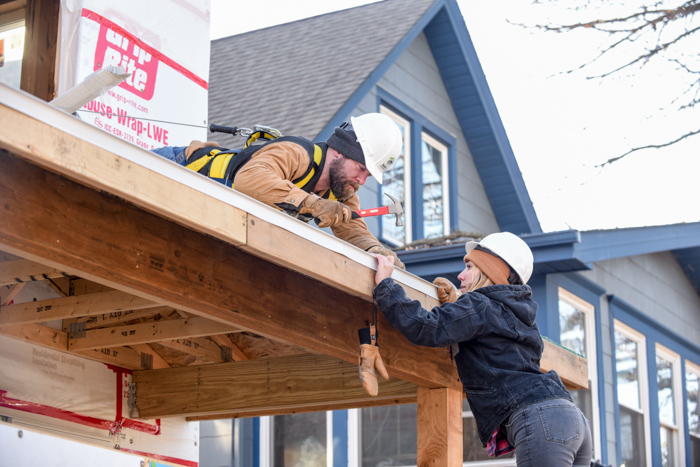 Two volunteers working on roof.