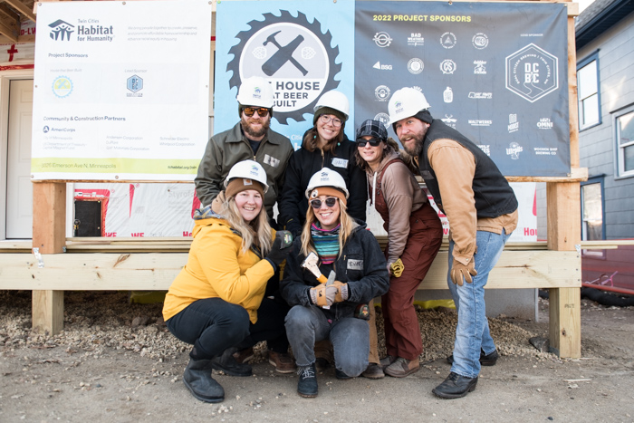 Six volunteers smiling outside of house.