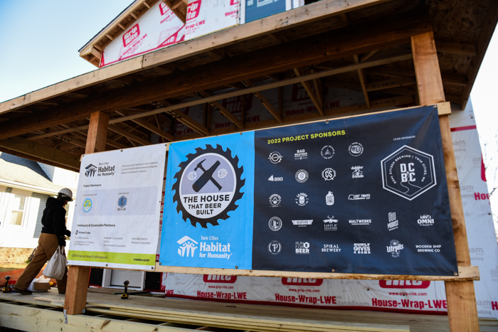 Banner with sponsors outside house.