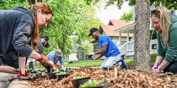 five volunteers doing a landscaping project