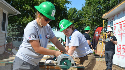 AmeriCorps using a saw.