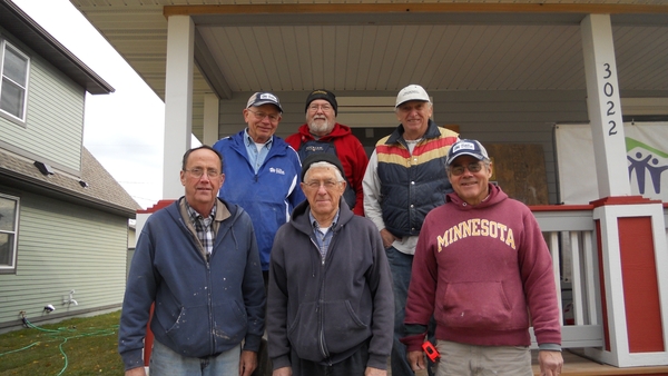 Volunteers on the porch of a finished home.