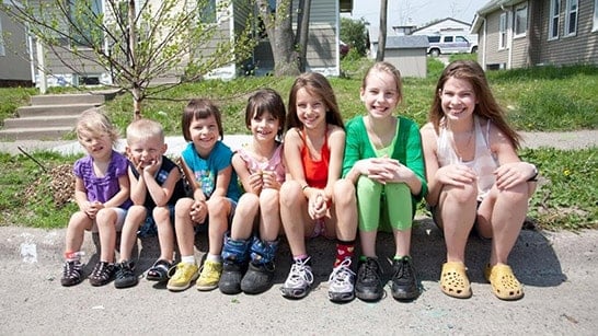 Kids sitting on a curb.