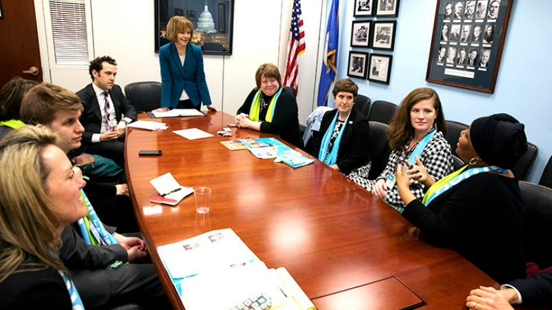 Senator Tina Smith, with Buffy speaking at a meeting.