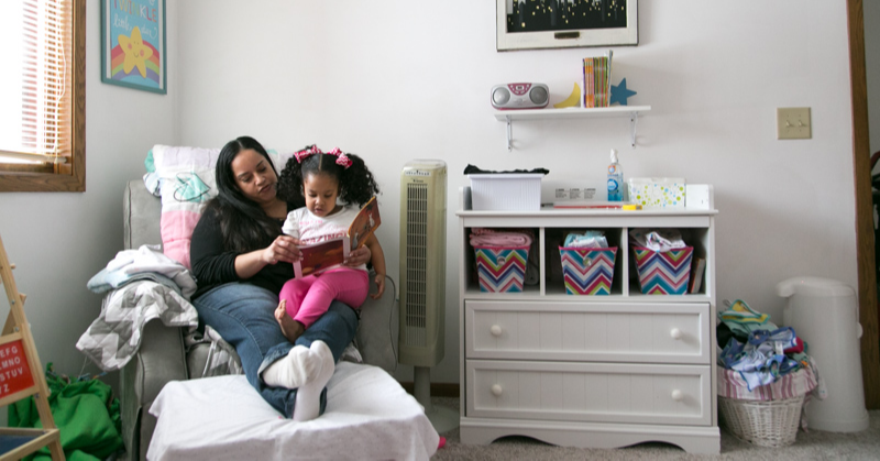 Kera reading with her daughter in their home.