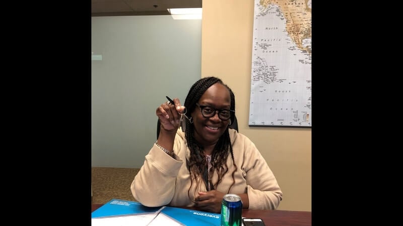 Wendy Mitchell holding her keys at her home closing.