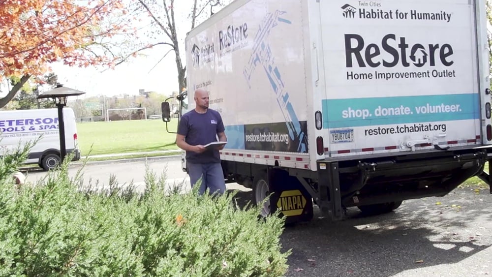 A ReStore staff member walking around the ReStore truck.