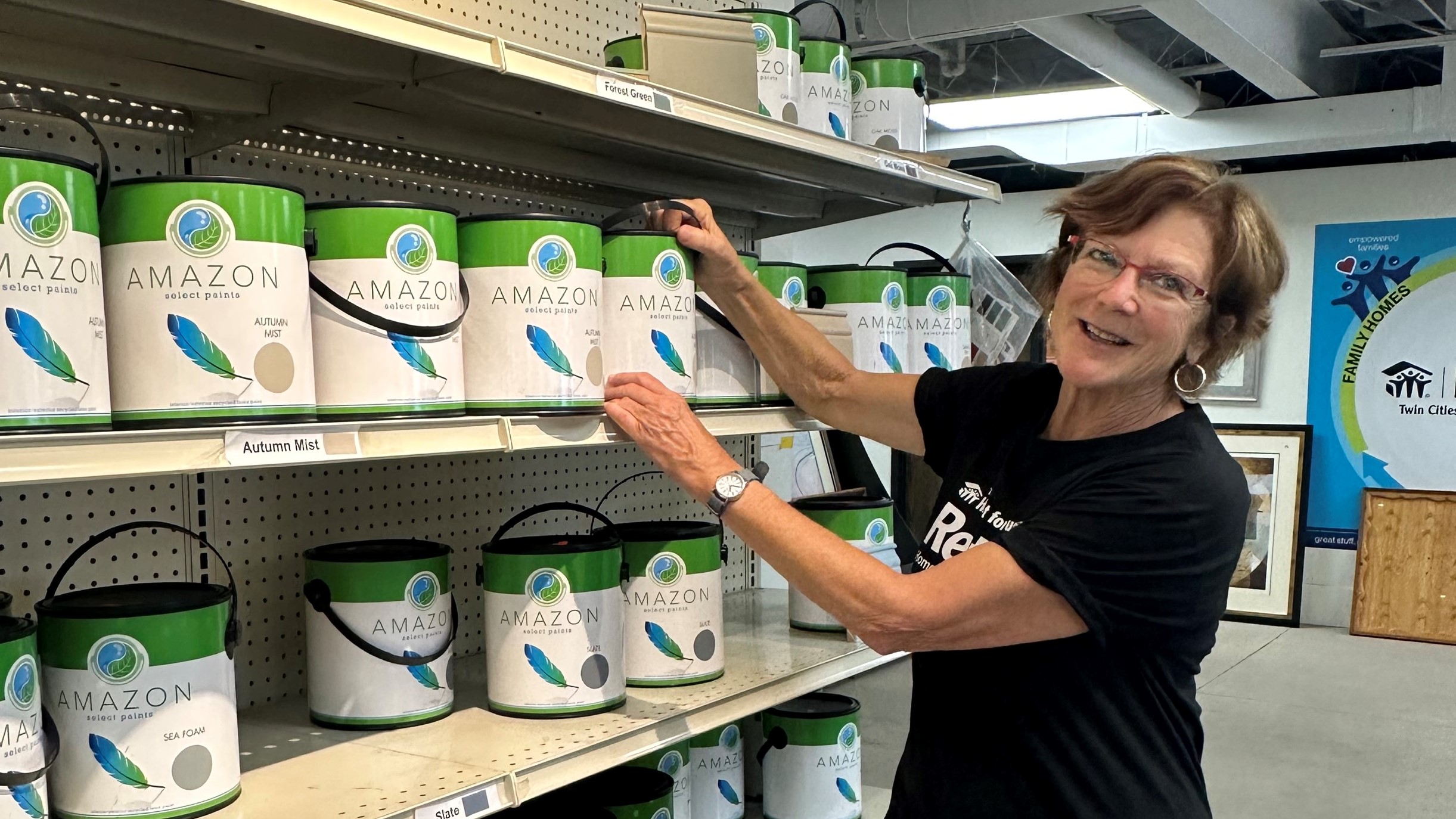Donna smiles as she stocks paint at ReStore.